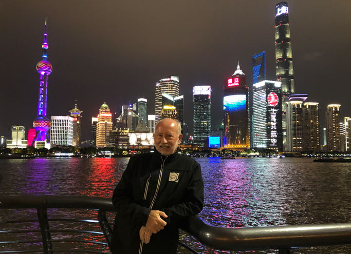 Blog author John Larmer standing in front of the city night skyline in China